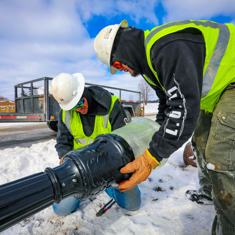 Two Harlan Electric workers installing a street light